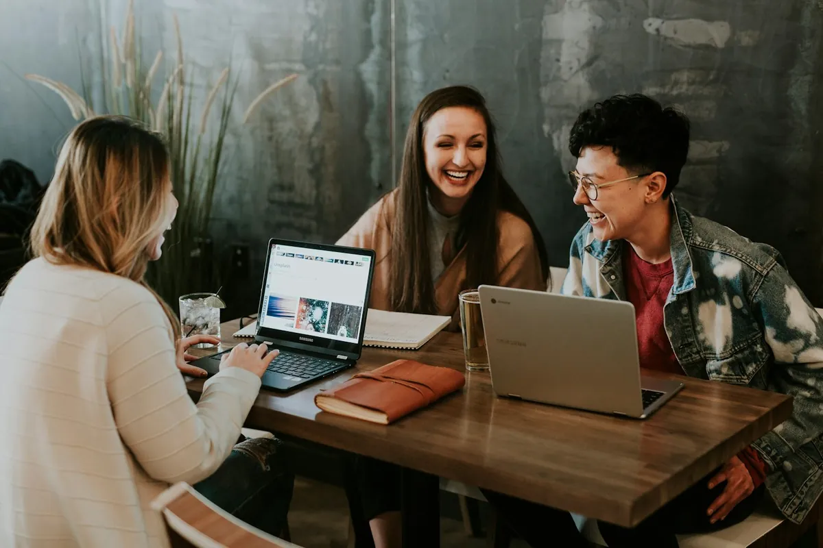 People collaborating around laptops at a shared work table